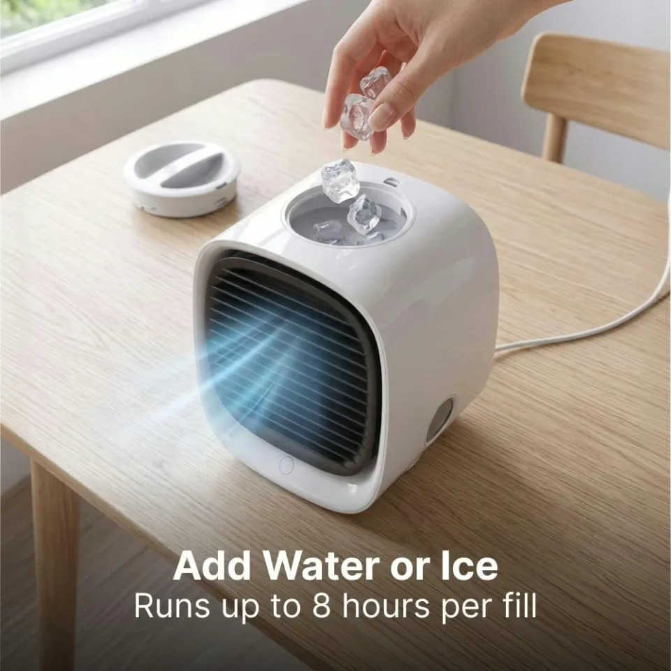 Hand dropping ice cubes into the open water tank of the AiraBreeze cooler on a wooden table — add water or ice and it runs up to 8 hours per fill